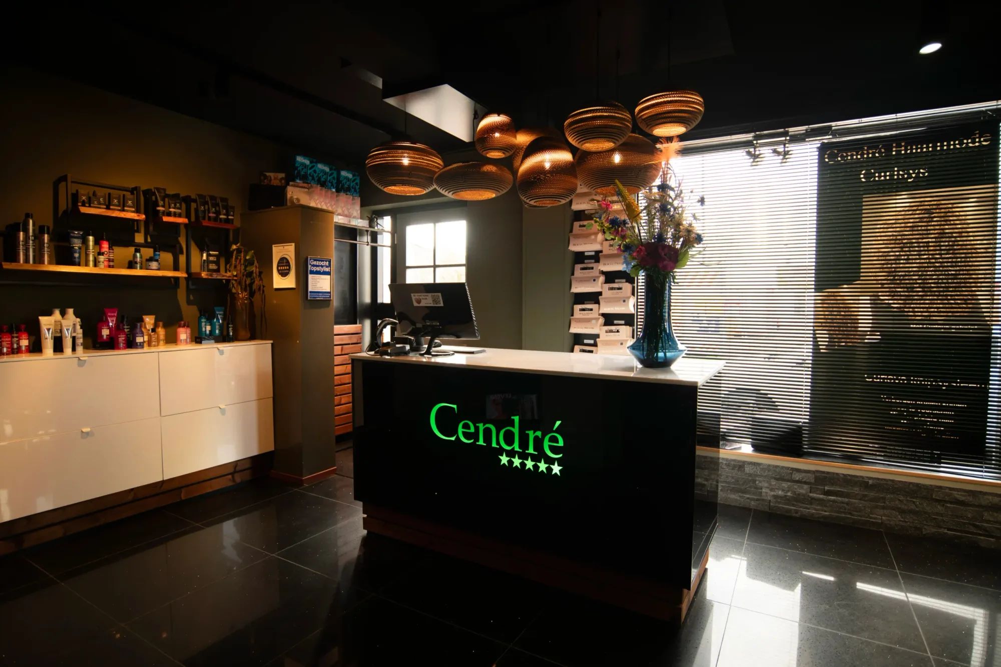 De balie met het verlichte Cendré-logo in de salon aan de Reggestraat